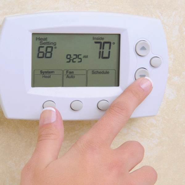Closeup of Hand and Thermostat
